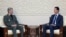 This photo released by the Syrian official news agency SANA, shows Syrian president Bashar al-Assad, right, meeting with Iran's defense minister Amir Hatami, in Damascus, Syria, Aug. 26, 2018. 