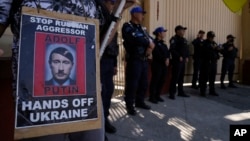Một người biểu tình cầm tấm áp phích in hình Tổng thống Nga Vladimir Putin với tư cách là nhà độc tài quá cố của Đức Adolf Hitler để phản đối việc Nga xâm chiếm Ukraine bên ngoài đại sứ quán Nga ở Mexico City ngày 24/2/2023.