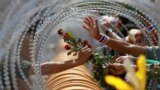 An anti-government protester gives a rose to a Thai soldier at the Defense Ministry during a rally in Bangkok.