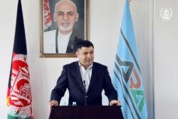 Fazel Fazly, another close aide to former Afghan President Ashraf Ghani, speaks in an undated photo at an unidentified location, with a portrait of Ghani behind him. (Source - former Afghan government)