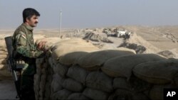 FILE - A militiaman of the Kurdistan Freedom Party, an Iranian Kurdish opposition group, looks over the sandbags at a section of the front line near the Iraqi city of Kirkuk, Sept. 5, 2016.