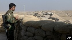 A militiaman of the Kurdistan Freedom Party, an Iranian Kurdish opposition group, looks over the sandbags at a section of the frontline near the Iraqi city of Kirkuk, Sept. 5, 2016.