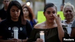 DACA计划的受惠者赫尔南德斯（左）和罗德里格斯9月5日在德州的圣哈辛托广场参加烛光集会