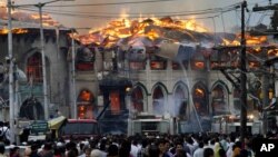 Kashmiri residents watch as firefighters try to extinguish a fire at the nearly 200-years-old Sheikh Abdul Qadir Jeelani Shrine, popularly known as Ghaus-e-Azam, or Dastgeer Sahab, in downtown Srinagar, India, June 25, 2012.