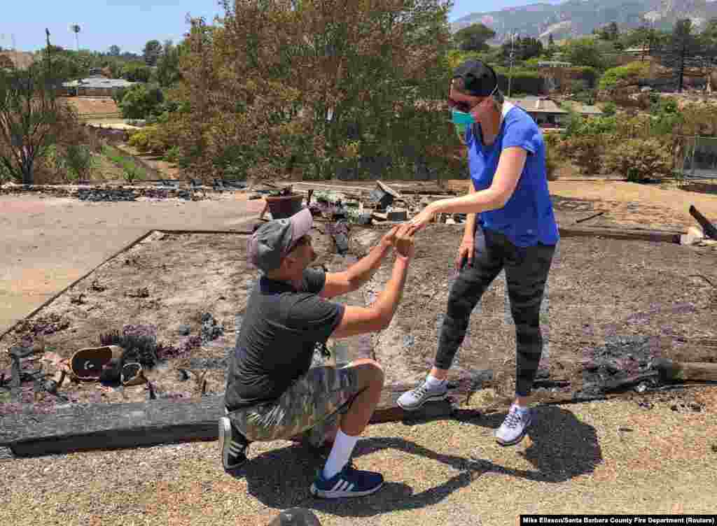 Ishu and Laura Rao return to the rubble of their home, which they lost in a wildfire, to retrieve their wedding rings, in Alameda, California, in this July 8, 2018 photo obtained from social media.