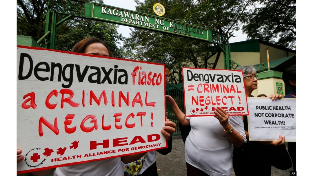 FILE - Protesters display placards during a rally outside the Department of Health as they demand accountability for government officials involved in the controversial immunization of the anti-dengue vaccine Dengvaxia to more than 700,000 Filipino childre