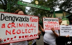 FILE - Protesters display placards during a rally outside the Department of Health as they demand accountability for government officials involved in the controversial immunization of the anti-dengue vaccine Dengvaxia to more than 700,000 Filipino childre