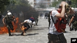 Riot police and demonstrators clash during protests against austerity measures in Athens, June 28, 2011.