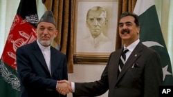 Afghan President Hamid Karzai, left, shakes hand with Pakistani Prime Minister Yousuf Raza Gilani prior to their meeting in Islamabad, Pakistan on Saturday, June 11, 2011