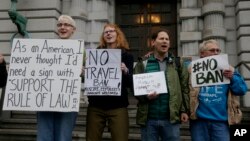 Kay Aull, from left, holds a sign and chants with Beth Kohn, Paul Paz y Mino and Karen Shore outside of the 9th U.S. Circuit Court of Appeals in San Francisco, Feb. 7, 2017. 