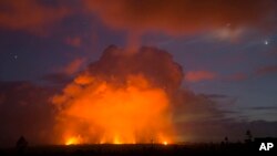 Volcanic activity from the Malama Ki and Leilani Estates neighborhoods glows in the distance from Hwy 137, May 17, 2018, near Pahoa, Hawaii