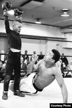 Ali & the Kid, Muhammad Ali has fun with a young child during a workout break, 1967. (George Kalinsky)