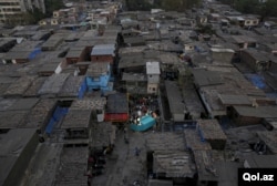 Residents gather around a mobile museum displayed on an improvised handcart in Dharavi, one of Asia's largest slums, in Mumbai, India, Feb. 18, 2016.