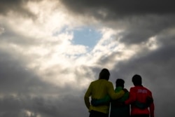 Brazil's Italo Ferreira, center, gold medal, Japan's Kanoa Igarashi, right, silver medal, and Australia's Owen Wright, bronze medal, pose for photographers in the men's surfing competition at the 2020 Summer Olympics, Tuesday, July 27, 2021