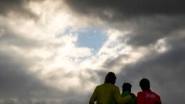 Brazil's Italo Ferreira, center, gold medal, Japan's Kanoa Igarashi, right, silver medal, and Australia's Owen Wright, bronze medal, pose for photographers in the men's surfing competition at the 2020 Summer Olympics, Tuesday, July 27, 2021