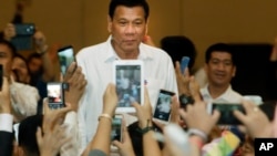 Philippine President Rodrigo Duterte, arrives a meeting with the Filipino community, in Phnom Penh, Cambodia, Tuesday, Dec. 13, 2016. Duterte on Tuesday arrived Phnom Penh on his two-day official to Cambodia. (AP Photo/Heng Sinith)