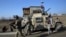 FILE - Security personnel arrive near the site of a suicide bombing near the Bagram Air Base in Parwan province of Kabul, Afghanistan, Dec. 11, 2019. The Bagram Air Base is the main American base north of the capital Kabul, the U.S. military said.