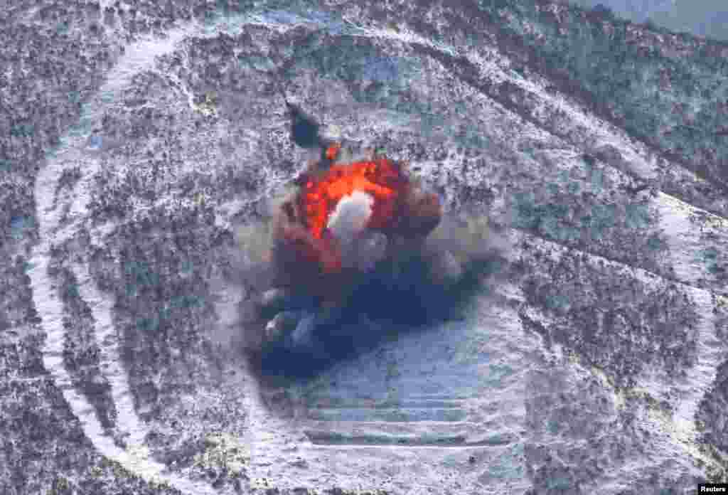 در این عکس که خبرگزاری رسمی کره شمالی 20 مارس 2013 منتشر کرد، واحدهای توپخانه نیروی هوایی و دفاع هوایی ارتش مردم کره در مانور نظامی هواپیماهای بدون سرنشین به اهدافی حمله می کنند. 