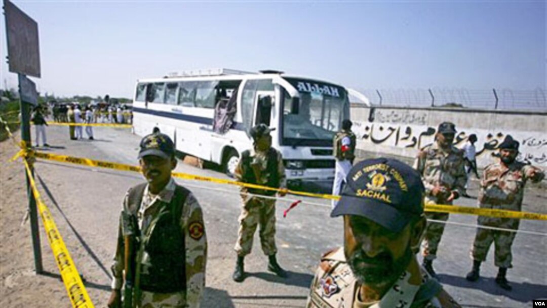 Tentara Pakistan berdiri di sekitar lokasi ledakan bom dekat dua bus di Karachi, Selasa (26/4).