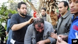 开罗解放广场上反政府示威者给法国摄影记者包伤口