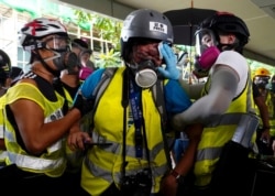 FILE - An injured journalist, center, is attended to by colleagues, in Hong Kong, Sept. 29, 2019.