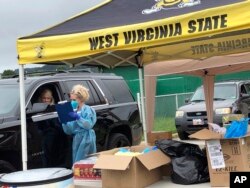 Parents and students arrive in their vehicles for health screenings and temperature checks before moving belongings into residence halls at West Virginia State University campus Friday, July 31, 2020, in Institute, W. Va. (AP Photo/John Raby)