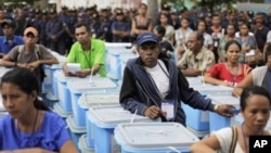 Electoral commission workers stand beside ballot boxes to be sent to villages in Dili, East Timor, March 16, 2012. 