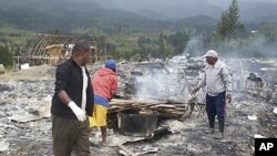 Villagers survey a damaged house of a candidate, where a meeting was to be held, after hundreds of supporters of two rival groups clashed at Ilaga in Puncak, West Papua province, Indonesia, August 1, 2011 (file photo)