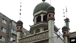 Members of the Uyghur ethnic minority walk past a Muslim mosque near the Erduoqiao neighborhood in Urumqi in northwestern China's Xinjiang Uygur Autonomous Region, (File).