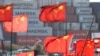 FILE - Chinese national flags flutter near shipping containers at the Yangshan Port outside Shanghai, Feb. 7, 2025.