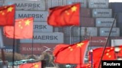 FILE - Chinese national flags flutter near shipping containers at the Yangshan Port outside Shanghai, Feb. 7, 2025.