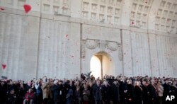 FILE - Red paper poppies fall from the ceiling during an Armistice Day ceremony at the Menin Gate in Ypres, Belgium on Nov. 11, 2014.