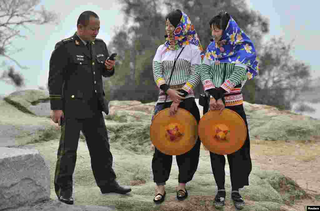 Seorang perwira militer China berbicara dengan dua pemandu wisata suku Hui&#39;an di kota Hui&#39;an, provinsi Fujian, China. 