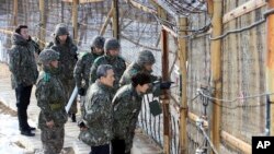 FILE - South Korean President Park Geun-hye, second right, looks at the North Korean side through a barbed wire fence during a 2013 trip to the Demilitarized Zone in Yanggu, South Korea.