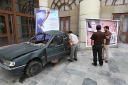 A man looks into the damaged car of Masoud Ali Mohammadi, an Iranian nuclear physics professor, who was killed in a bomb attack in Jan. 2010, during a conference in Tehran, May 14, 2011.