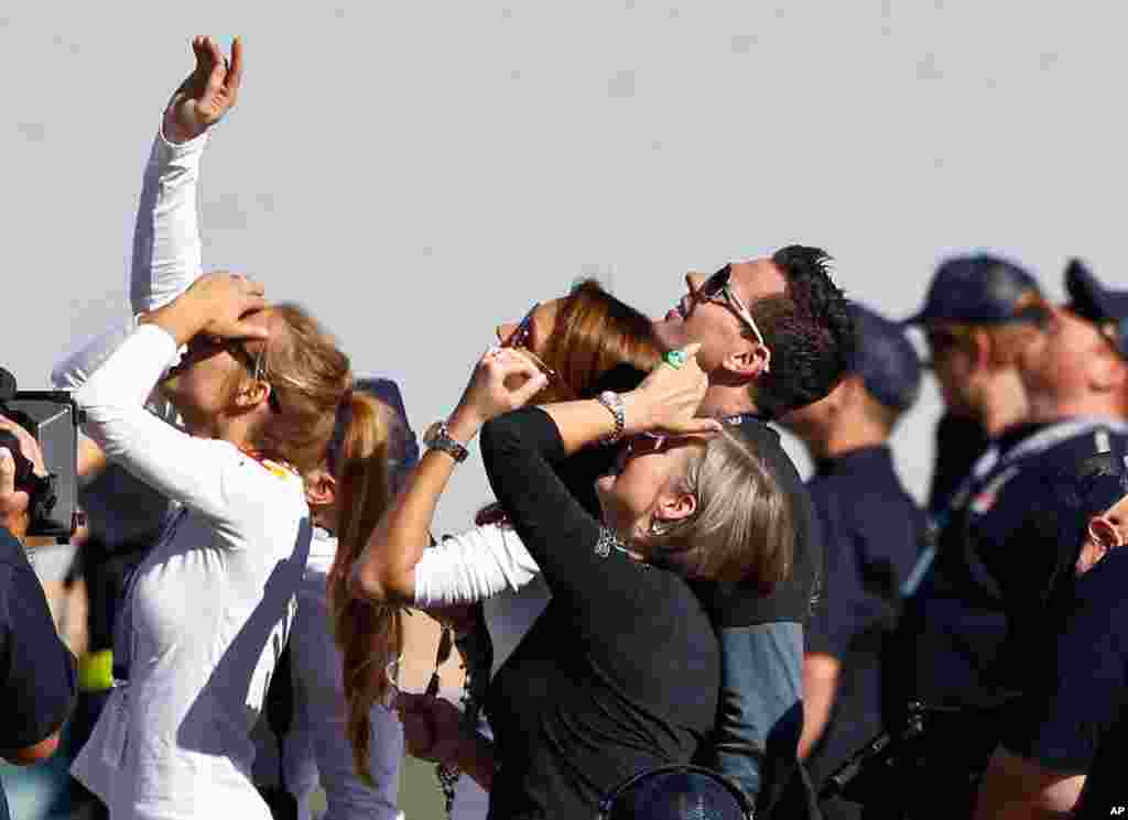 Felix Baumgartner's mother Ava Baumgartner, middle, watches with other family members and friends as his capsule lifts off.