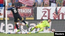 Clint Dempsey (8) vence la resistencia del arquero paraguayo, Justo Villar, para darle el triunfo a Estados Unidos, 1-0.