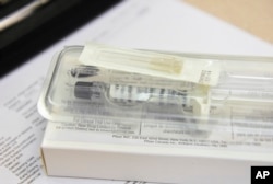 This March 29, 2017 photo shows a syringe involved in an experimental non-opioid pain medication trial at the Altoona Center for Clinical Research in Altoona, Pennsylvania.