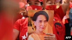 Seorang migran memegang foto Aung San Suu Kyi dalam aksi unjuk rasa di luar Kedutaan Myanmar di Bangkok, 1 Februari 2021. (Foto: dok).