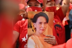 ពលករចំណាកស្រុកមីយ៉ាន់ម៉ាកាន់រូបអ្នកស្រី Aung San Suu Kyi ពេលធ្វើបាតុកម្មនៅមុខស្ថានទូតមីយ៉ាន់ម៉ាក្នុងទីក្រុងបាងកក ប្រទេសថៃ ថ្ងៃទី១ ខែកុម្ភៈ ឆ្នាំ២០២១។