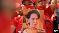 ពលករចំណាកស្រុកមីយ៉ាន់ម៉ាកាន់រូបអ្នកស្រី Aung San Suu Kyi ពេលធ្វើបាតុកម្មនៅមុខស្ថានទូតមីយ៉ាន់ម៉ាក្នុងទីក្រុងបាងកក ប្រទេសថៃ ថ្ងៃទី១ ខែកុម្ភៈ ឆ្នាំ២០២១។