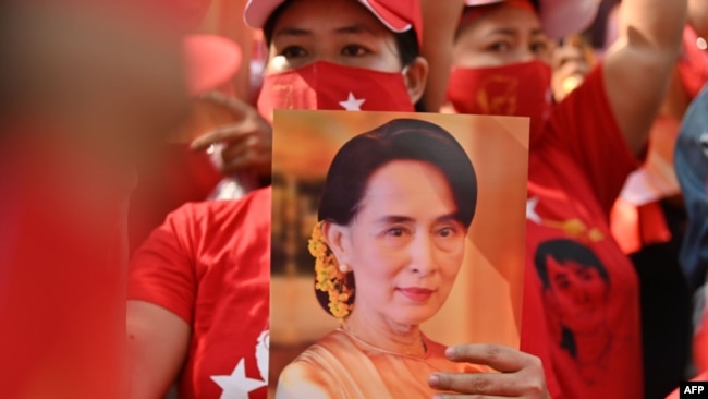 A Myanmar migrant holds up an image of Aung San Suu Kyi