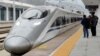 FILE - A high-speed railway train linking Shanghai and Kunming, of Yunnan province, is seen at a station during a partial operation, in Anshun, Guizhou province, China, Dec. 28, 2016. 