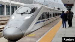 FILE - A high-speed railway train linking Shanghai and Kunming, of Yunnan province, is seen at a station during a partial operation, in Anshun, Guizhou province, China, Dec. 28, 2016. 