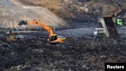 Para pekerja tambang mengoperasikan truk dan mesin di tambang batu bara milik PT Exploitasi Energi Indonesia Tbk di kabupaten Palaran, Samarinda, Kalimantan Timur. (Reuters/Zevanya Suryawan) 