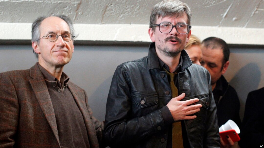 Kepala redaksi Charlie Hebdo yang baru, Gerard Biard, kiri, dan kartunis Renald Luzier, pada sebuah konferensi pers di Paris.