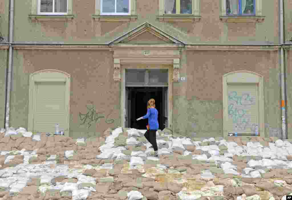 A woman stands on a wall of sandbags in front of a house in Dresden, eastern Germany. Heavy rainfalls have caused flooding along rivers and lakes in Germany, Austria, Switzerland and the Czech Republic.