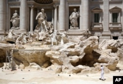 Workers clean the inside of the Trevi Fountain during a one-day routine maintenance, in Rome, July 10, 2017.