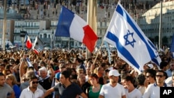 Supporters of Israel’s Gaza offensive wave Israeli and French flags at a demonstration in Marseille, France, July 27, 2014. The radical Jewish Defense League, not shown, uses strong-arm tactics to fight anti-Semitism.