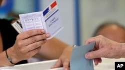 FILE - A man casts his ballot in parliamentary elections at a polling station in Marseille, southern France, June 18, 2017. 